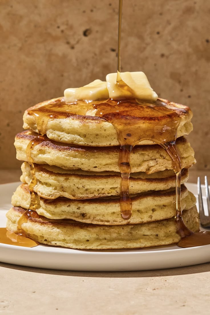Stack of pancakes with bacon and eggs